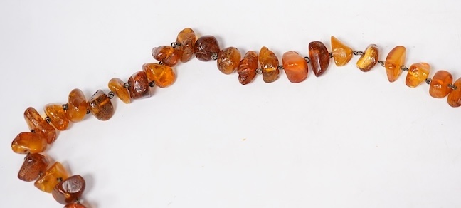 Three assorted amber necklaces including a single strand graduated oval bead necklace, 40cm, gross weight 37 grams, the other two necklaces gross weight 240 grams. Condition - poor to fair